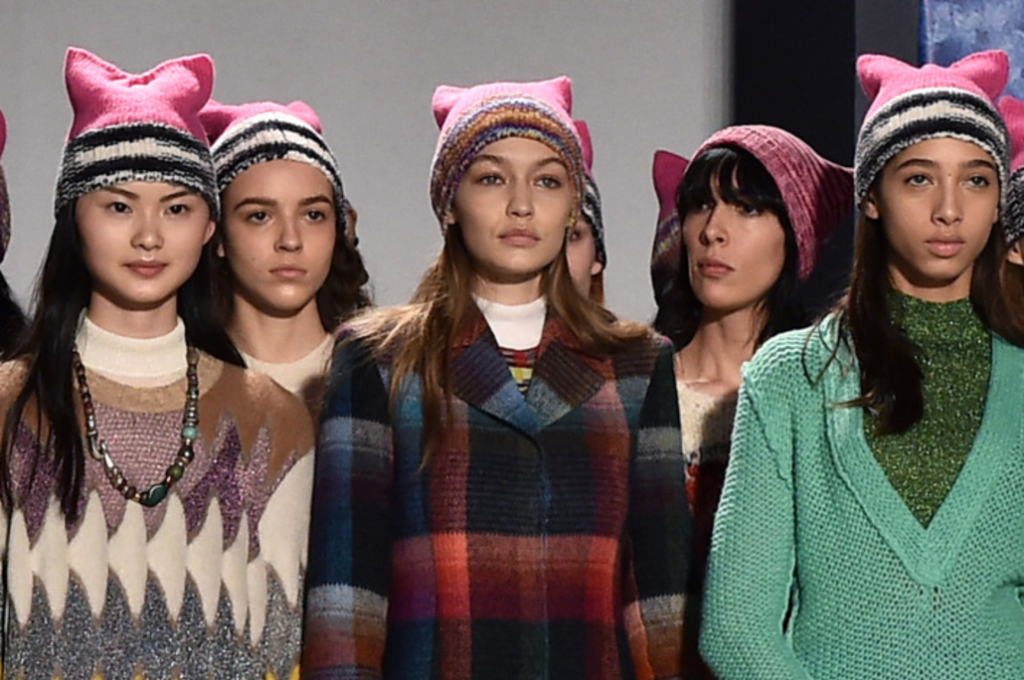 Female models wearing pink knitted pussy hats designed by Missoni stood together on a stage in Milan.