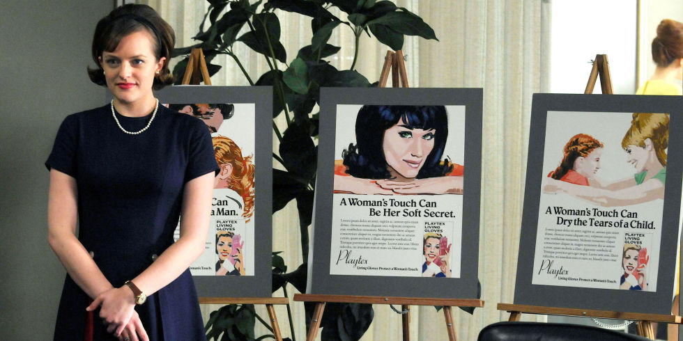 An image from Mad Men of a woman stood in front of three marketing idea boards.
