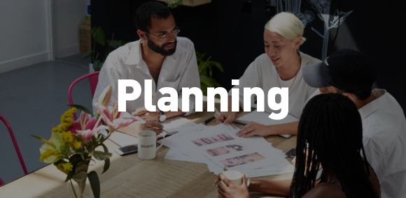 Caption: Planning

Image of people sat around table