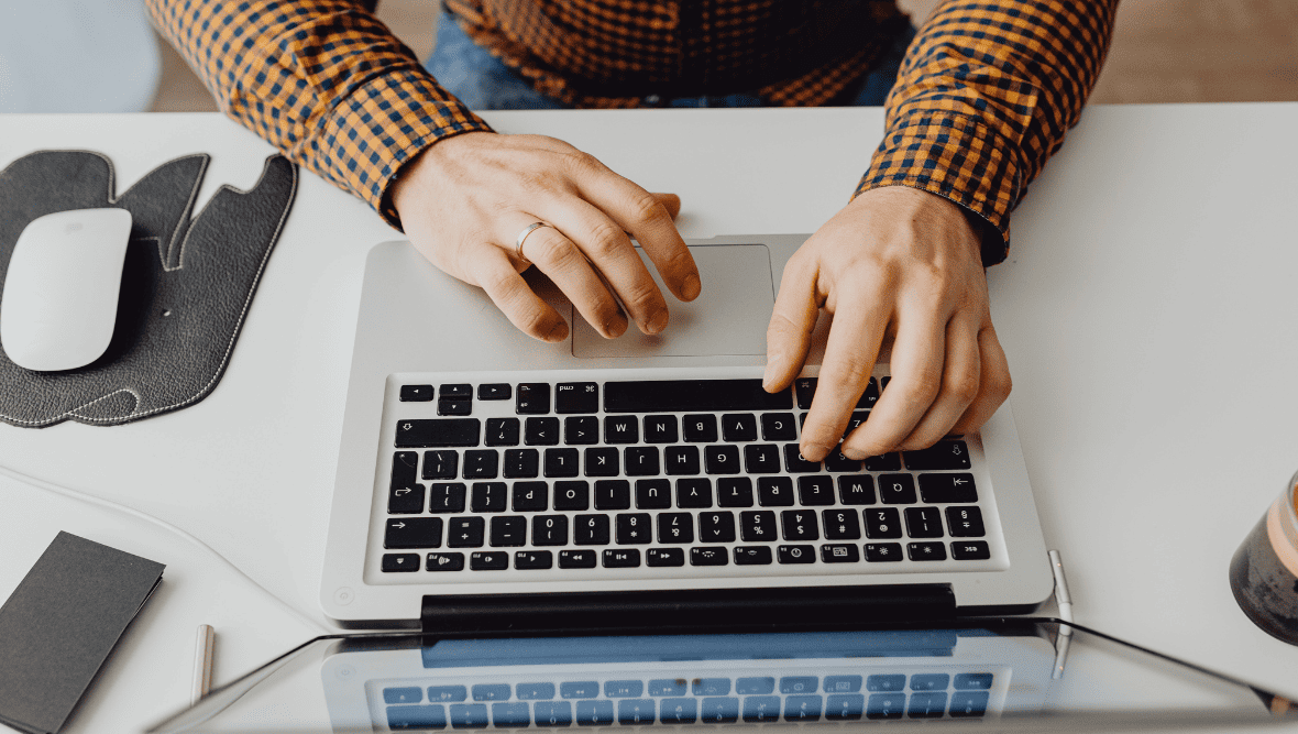 overhead shot of male hands working on laptop.