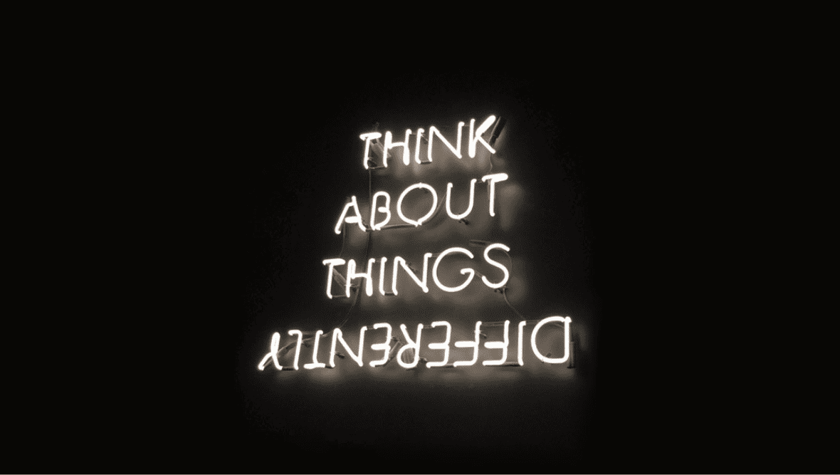 Neon lights that say "think about things differently" the last word is upside down