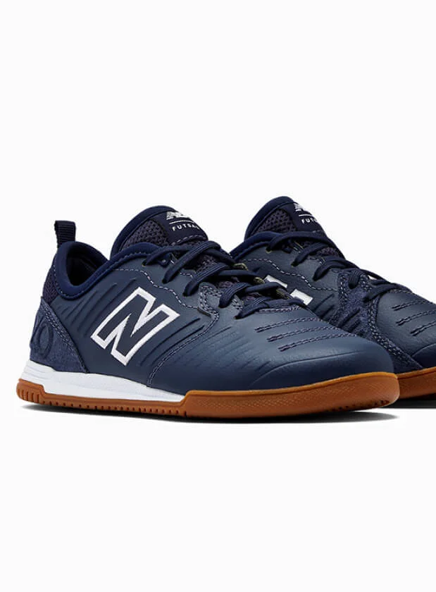 Navy blue New Balance trainers on white background.