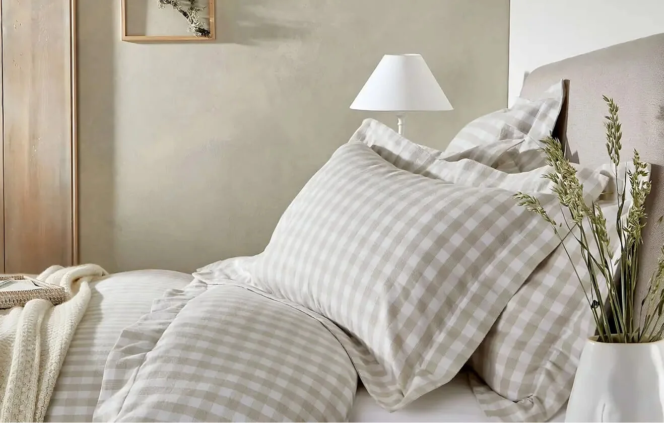 Side shot of beige gingham bedding from The White Company.