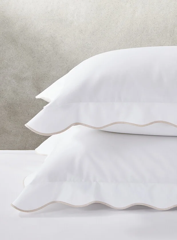 Two plump pillows with white housewife pillow cases with beige edging from The White Company.