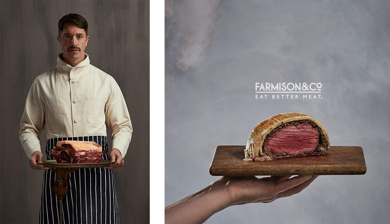 Farmison & Co butcher holding tray of raw meat in front of grey background.