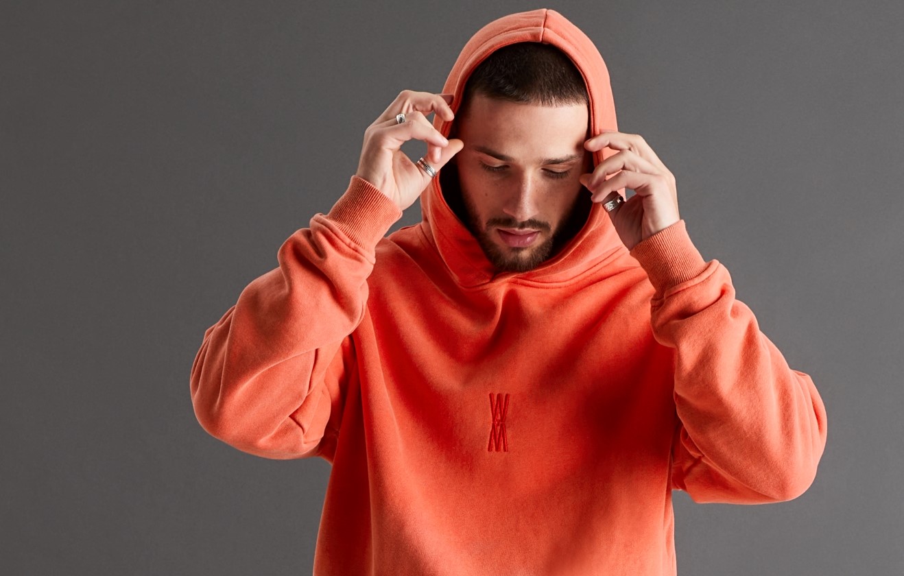 Male model wearing orange WXM hoodie.