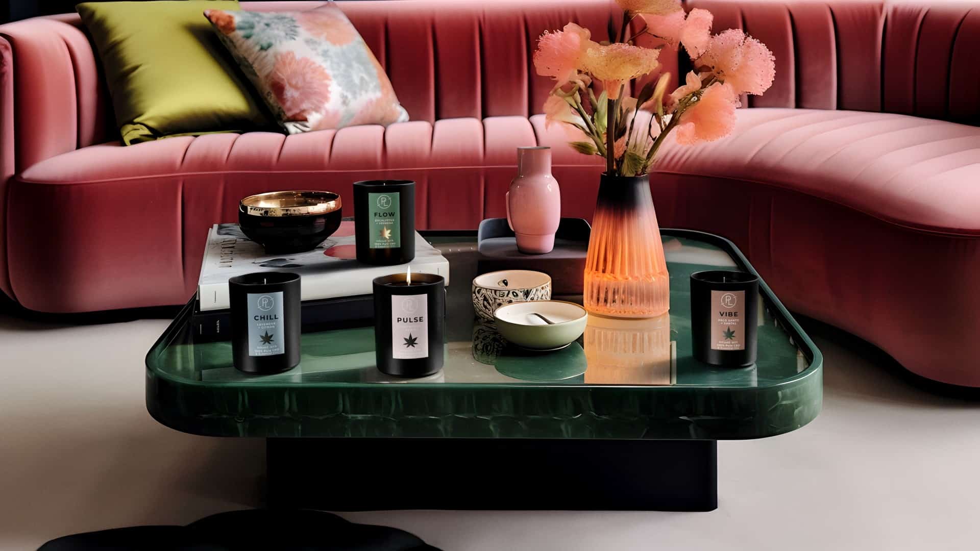 Green coffee table with PartyLite CBD candle collection and pink sofa in background.