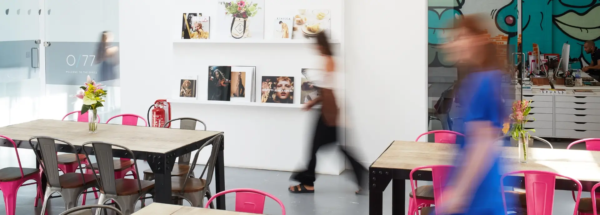 Seventy7 London office with blurred silhouettes of people moving.