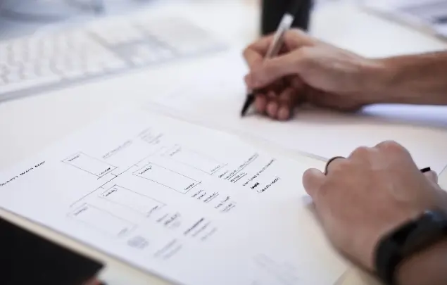 Blurred shot of two hands drawing in black ink.