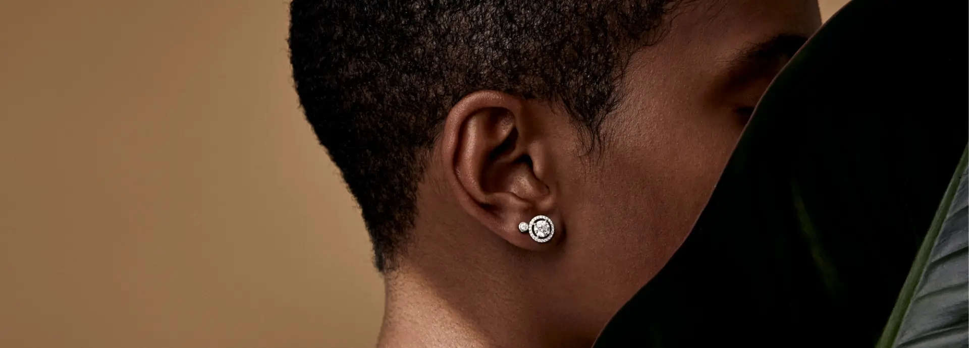 Side profile of short haired model wearing diamond stud earring.