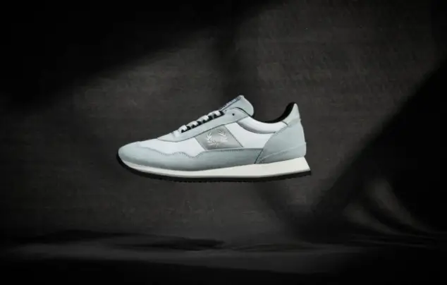 Trainer shoe hovering in front of black background.