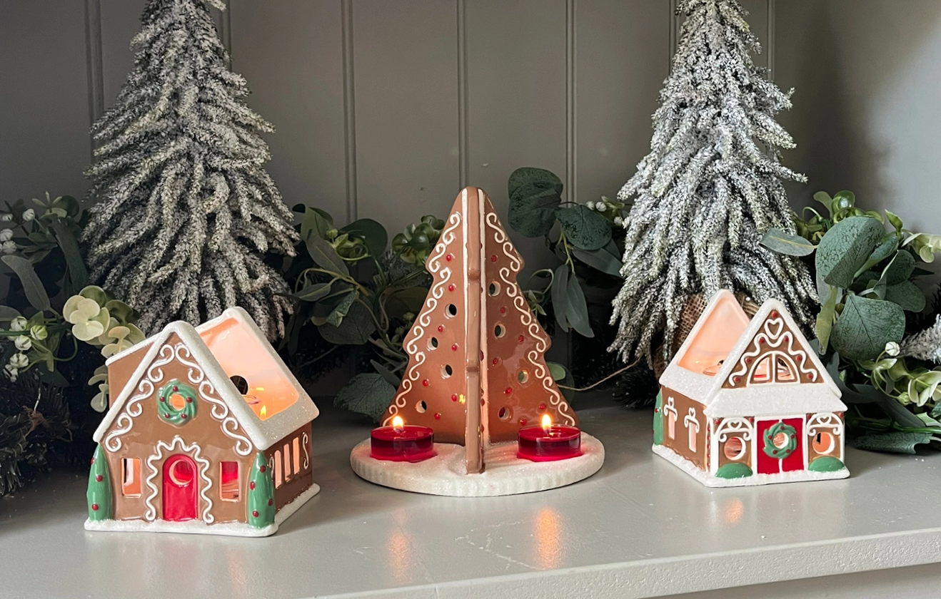 A shelf display with three of PartyLite's ceramic christmas tealight holders.