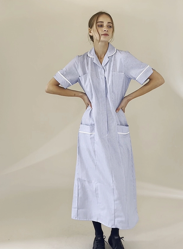 Woman in neutral photography set up wearing a long pale blue nursing tunic from Simon Jersey.
